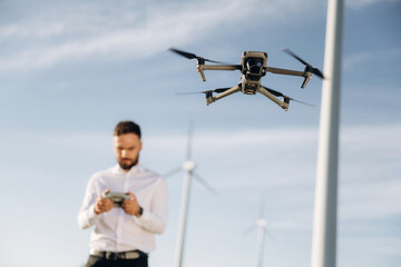 Controlling the drone. Engineer in field checking on wind turbine production