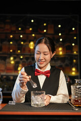 Professional female bartender preparing alcoholic drinks in a bar