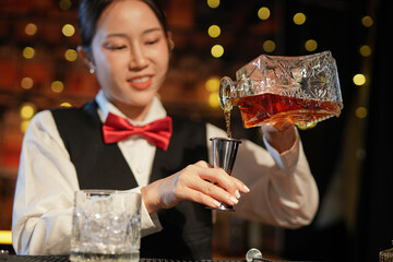 Professional female bartender preparing alcoholic drinks in a bar
