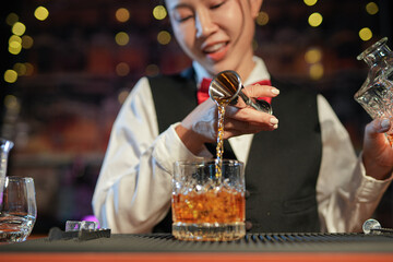 Professional female bartender preparing alcoholic drinks in a bar