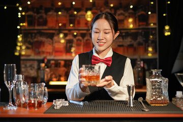  Professional female bartender preparing alcoholic drinks in a bar