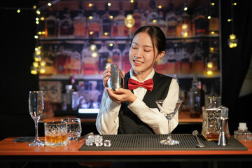 Professional female bartender preparing alcoholic drinks in a bar