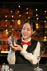 Professional female bartender preparing alcoholic drinks in a bar