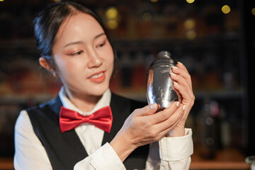 Professional female bartender preparing alcoholic drinks in a bar