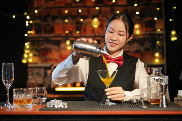 Professional female bartender preparing alcoholic drinks in a bar