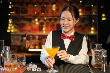 Professional female bartender preparing alcoholic drinks in a bar