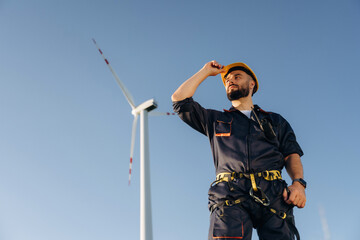 Break time, standing. Engineer in field checking on wind turbine production