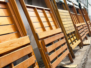 Obraz premium Wooden folding tables lined up outdoors near building with green awning