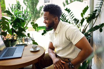 Man sitting in coffee shop using laptop for work.