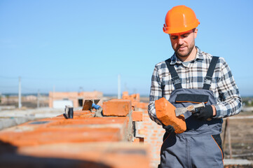 Portrait of a builder in the process of working on a construction site outdoors