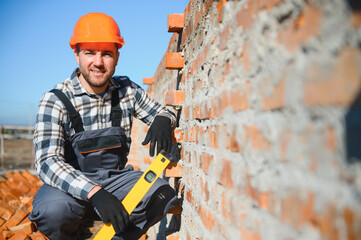 Portrait of a builder in the process of working on a construction site outdoors