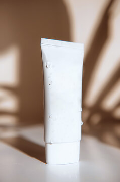 Sunscreen Tube with UVA and UVB Protection in jar on white table with sun light and shadow