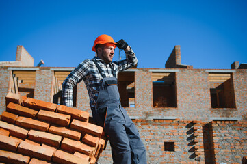 Portrait of a builder in the process of working on a construction site outdoors