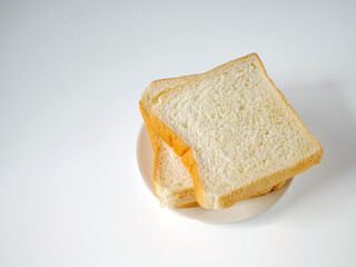 White sliced bread stacked on the white wooden table, top view