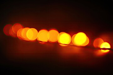 Blurred row of warm orange lights on dark background