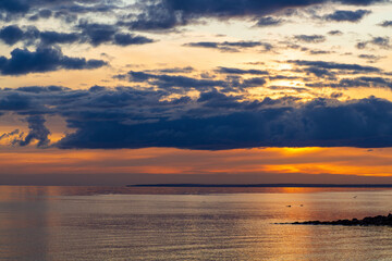 Beautiful sunset at the beach.  The sky is painted in bright colors. Calm summer evening.