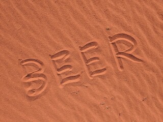 BEER writen in hot sand of desert WADI RUM in Jordan Arabia thirst on long distance Jordan trail