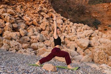 Practicing yoga on a calm beach during sunset
