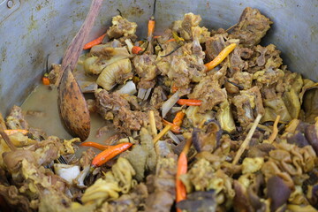 Traditional Indonesian tongseng kambing, a spicy goat meat curry cooked with chilies, cabbage, and...