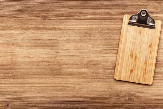 Wooden clipboard on light brown wood table