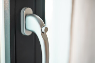 Woman opens a glass door or window handle with security lock button.
