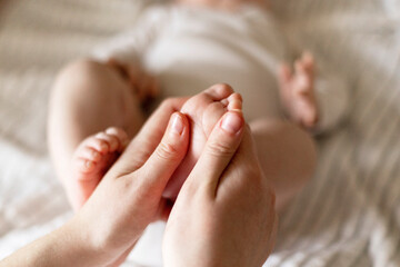 Parent Gently Touching Baby's Feet on Bed