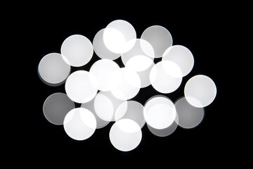 Abstract cluster of blurred, white circles on a black background