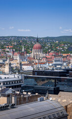 Panoramic view of Budapest with the iconic Hungarian Parliament and Buda Hills, captured from the observation deck of St. Stephen’s Basilica on a clear summer day.