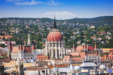Panoramic view of Budapest with the iconic Hungarian Parliament and Buda Hills, captured from the observation deck of St. Stephen’s Basilica on a clear summer day.