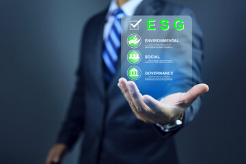 ESG environment social governance concept with businessman holding a virtual screen in hand to show...
