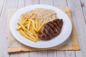 Grilled picanha beef, rice, farofa and french fries. Typical brazilian executive dish