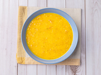 Pumpkin and jerked beef soup in a bowl over wooden table