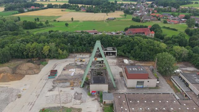 Flug von einem einzelnen F&ouml;rderturm einer zur&uuml;ckgebauten Zeche im Ruhrgebiet bei wolkigen Himmel im Hochsommer