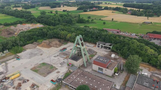 Flug um einen einzelnen F&ouml;rderturm einer zur&uuml;ckgebauten Zeche im Ruhrgebiet bei wolkigen Himmel im Hochsommer