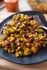 Delicious vegan salad with red lentils, kidney beans and yellow bell peppers on a plate