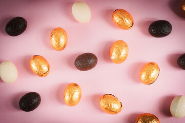 Mix chocolate eggs on a pink background.