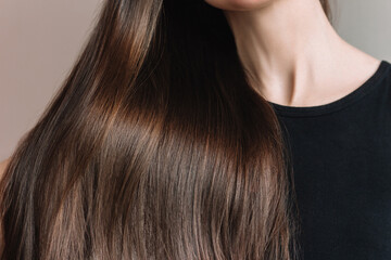 Young Caucasian brunette woman demonstrating her beautiful long shiny smooth healthy hair. 