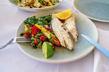 Pieces of fried fish with different vegetables. Balkan cuisine, healthy food