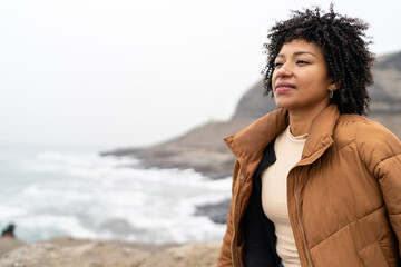 Woman enjoying a misty morning by the sea, reflecting and changing routine