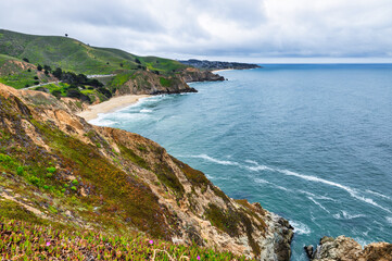 Dramatic ocean cliffs and lush coastal hills seen from Devils Bunker overlook, near Gray Whale Cove...