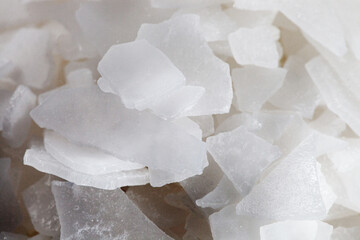 Magnesium chloride flakes. Industrial desiccant material for de-icing roads or dust control....