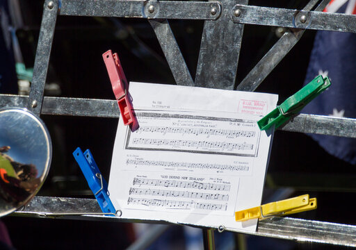 Sheet music on stand held down with coloured pegs