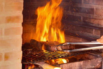 Sizzling Steaks Grilling Over Open Flames in a Brick BBQ
Thick cuts of meat sizzle on a grill over...