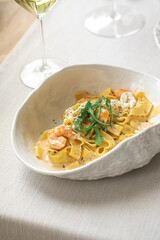 Fettuccine pasta with shrimp and creamy sauce garnished with arugula