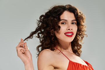 Charming young woman enjoying summer days with a confident smile and flowing curls