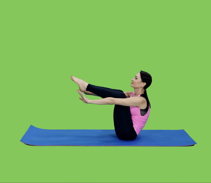 Slim fit mid adult woman doing abs exercises workout sitting on mat on green chroma key background, Bodyweight training