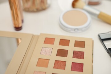Different makeup products on white table, closeup