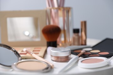 Different makeup products on white table indoors, closeup