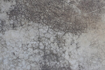Cracked concrete surface with dark staining and circular patterns