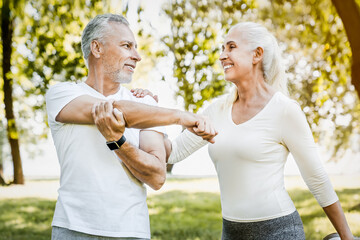 Elderly couple in park, retired active people family exercising together in sportswear, enjoying nature, showcasing love and motivation for fitness goals. Sport lifestyle rehabilitations concept